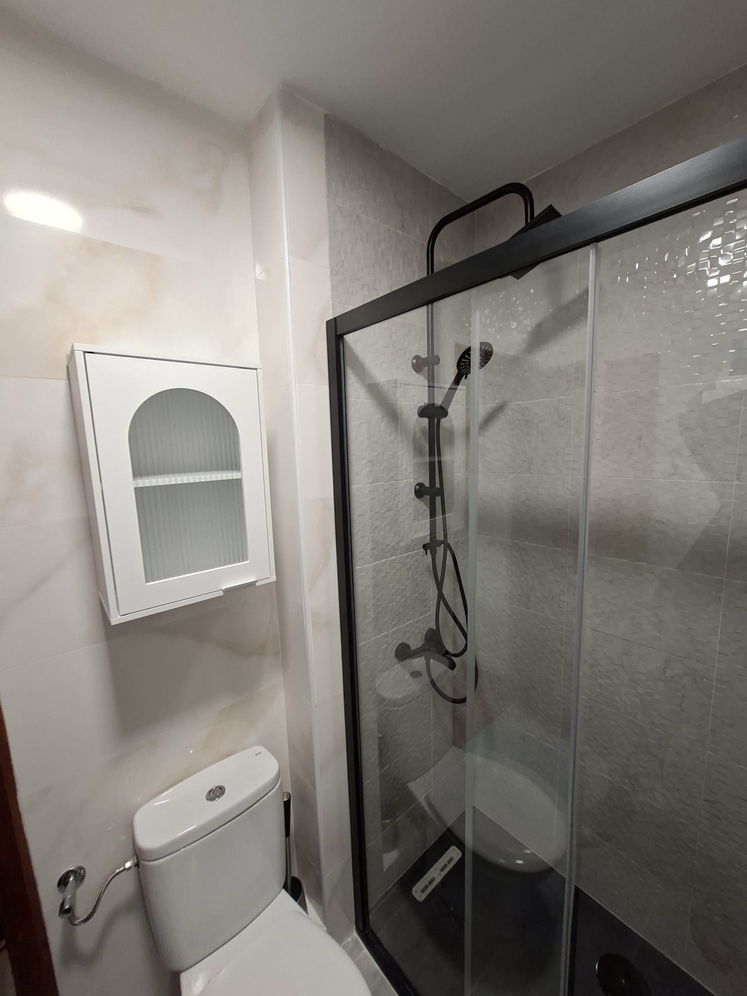 Reforma de baño moderno con mampara negra en A Coruña — E-Renova