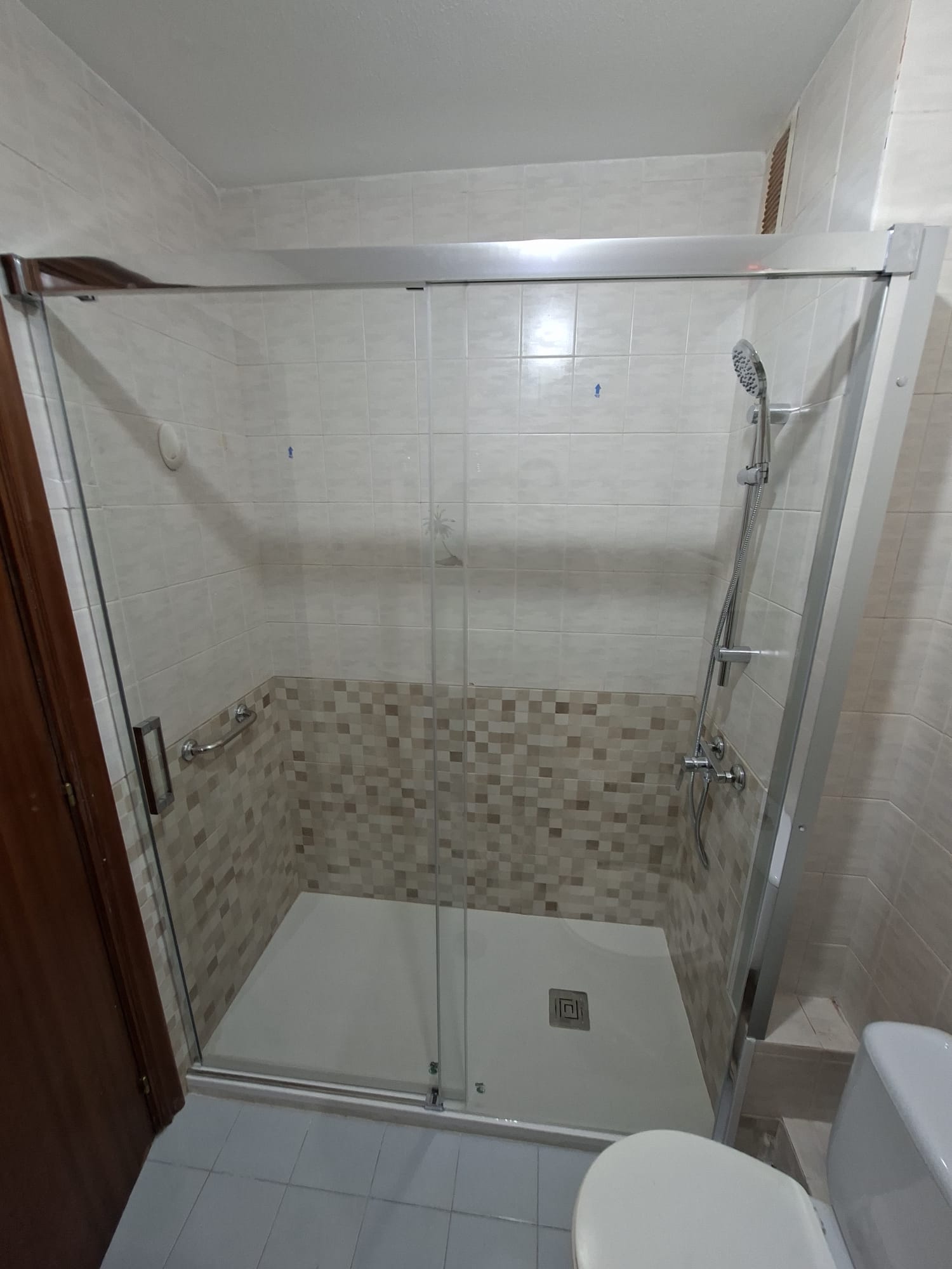 Ducha de obra con cenefa de mosaico en reforma de baño en Coruña